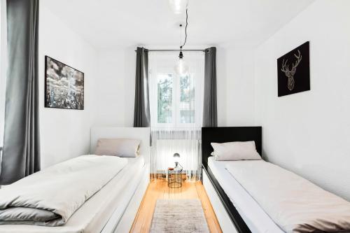 two beds in a room with white walls at Ferienwohnung Südschwarzwald in Wehr