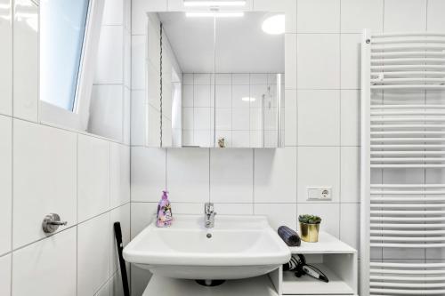 a white bathroom with a sink and a toilet at Ferienwohnung Südschwarzwald in Wehr