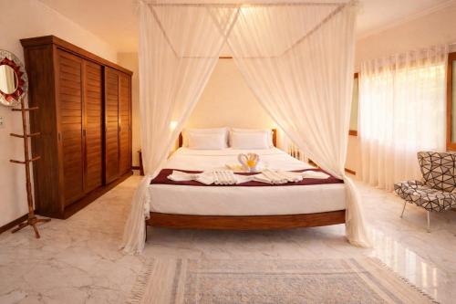 a bedroom with a canopy bed in a room at Residence Pé na Areia in Arraial d'Ajuda