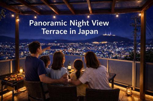 a group of people sitting on a viewing deck at night at Inasa Worlds Top Night View Retreat稲佐パノラマ夜景1棟貸切 in Nagasaki