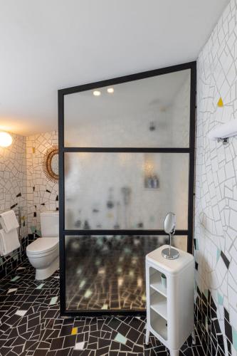 a bathroom with a toilet and a glass window at Le Cloître in Arles