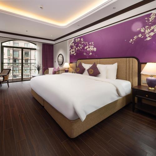 a bedroom with a large bed and a purple wall at Imperial Dalat Hotel, BW Premier Collection in Da Lat