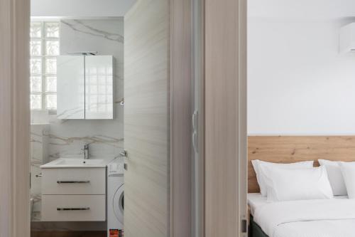 ein Schlafzimmer mit einem Bett, einem Waschbecken und einem Spiegel in der Unterkunft Sea Residence Complex in Ofrynio