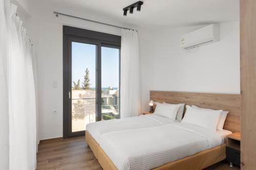 ein Schlafzimmer mit einem Bett und einem großen Fenster in der Unterkunft Sea Residence Complex in Ofrynio