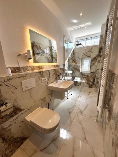 a bathroom with a toilet and a sink at Hotel Zu den Linden in Dresden
