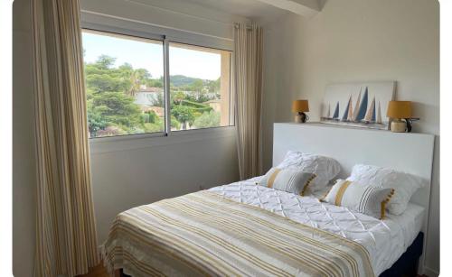 a bedroom with a bed with a large window at Villa Osher in Saint-Raphaël