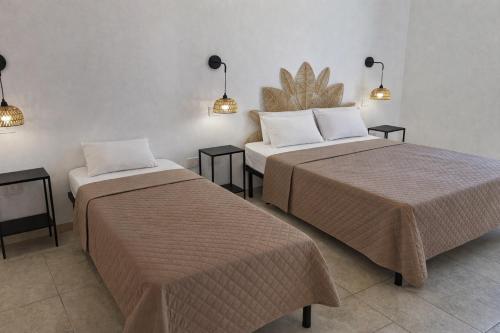 a room with two beds and two tables and lights at Masseria Coccolo in Carovigno