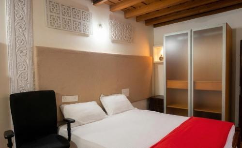 a bedroom with a bed and a black chair at Amma Stays and Trails in Kotikulam