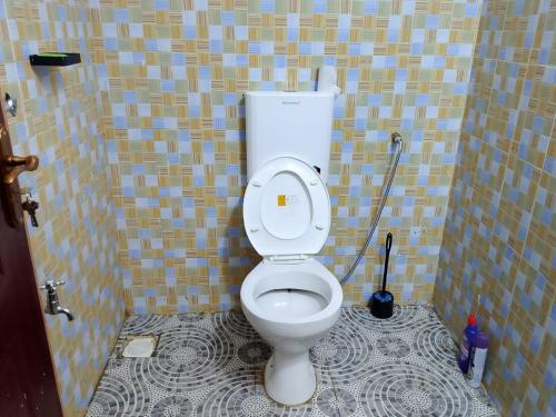 a bathroom with a toilet in a tiled room at Mwembe Airbnbs in Kisii