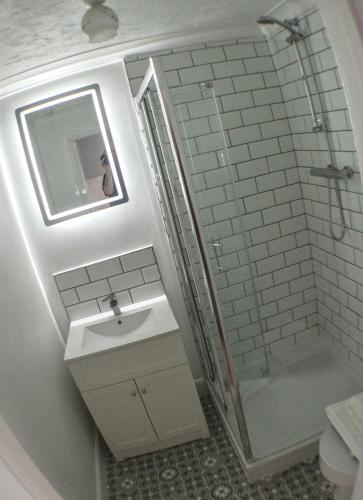 a white bathroom with a sink and a shower at The Chateau by MPH Holidays in Great Yarmouth