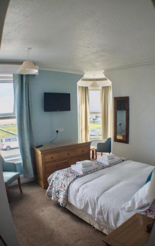 a bedroom with a large bed and a television at The Chateau by MPH Holidays in Great Yarmouth
