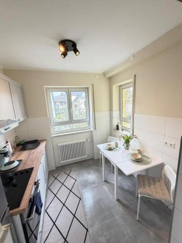 a kitchen with a white table and a table and chairs at K10 Living in Karlsruhe