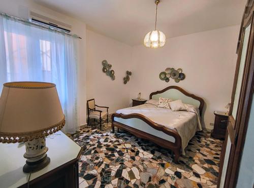 a bedroom with a bed and a lamp and a window at A cà du Piero in Albisola Superiore