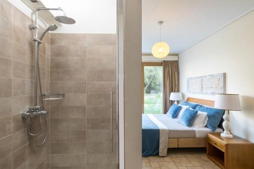 a bedroom with a bed and a shower at Three Stones Villas by Rodostamo Collection in Kassiopi