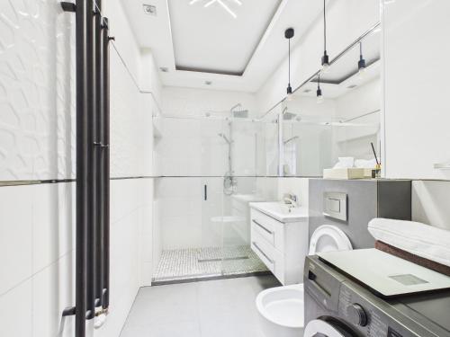 ein weißes Badezimmer mit Dusche und Toilette in der Unterkunft Centrum Marzeń in Suwałki