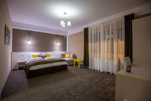 una habitación de hotel con una cama y un sofá en French Boutique, en Brasov