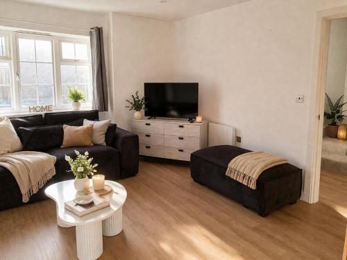 a living room with a couch and a tv at Beautiful Modern Home in Wisbech with Private Garden in Wisbech Saint Mary