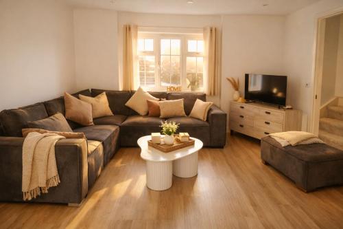 a living room with a couch and a coffee table at Beautiful Modern Home in Wisbech with Private Garden in Wisbech Saint Mary