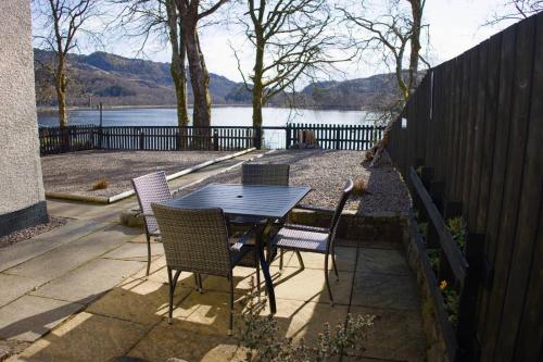 a table and chairs with a view of a lake at Number 4, Loch Shiel View in Glenfinnan