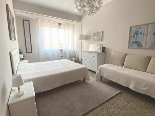 a white bedroom with a bed and a couch at Casa Carmen Vicchio, natura vicino a stazione e Mugello Circuit in Vicchio
