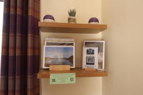 a shelf with pictures on it next to a curtain at Number 4, Loch Shiel View in Glenfinnan