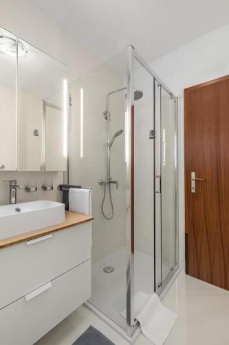 a bathroom with a shower and a sink at Holiday home with several apartments, a pool, sea views and a barbecue near Split in Podstrana
