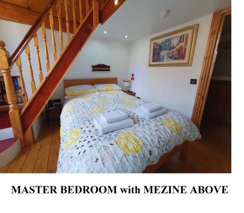 a bedroom with a bed with a wooden staircase at FREE DOG STAY - LARGE APARTMENT - Walk in Shower -FULL Kitchen - Free On Street Parking, NETFLIX - Super Fast WiFi - DVD's-Welcome Tray - No Deposits - Just Meters from Gavin n Stacey Film House in Barry