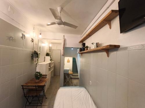 a room with a bed and a ceiling fan at Estúdio Madragoa in Lisbon
