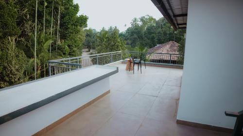 a balcony of a house with a view of trees at SafeStay Wayanad - 1BHK & 2BHK with Kitchen Facilities in Wayanad