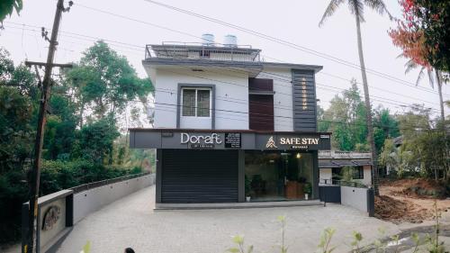 a store front of a building with a sign on it at SafeStay Wayanad - 1BHK & 2BHK with Kitchen Facilities in Wayanad