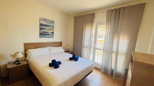 a bedroom with a bed with two blue pillows on it at Casa Vista Mar Oliastur El Cotillo in El Cotillo