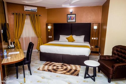 a hotel room with a bed and a desk and a chair at Pearl Paradise Resort by 4E in Finima