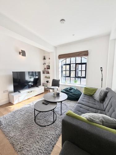 a living room with a couch and a table at Modern 2 Bedroom Apartment in Kings Cross, London, N1 in London