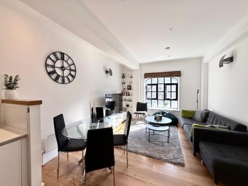 a living room with a table and a couch at Modern 2 Bedroom Apartment in Kings Cross, London, N1 in London
