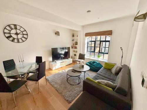 a living room with a couch and a table at Modern 2 Bedroom Apartment in Kings Cross, London, N1 in London