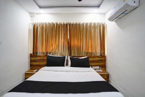 a bedroom with a large bed and a window at Hotel O Apollo in Bodakdev