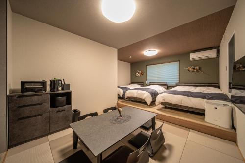 a bedroom with two beds and a table in it at 在-Zai- in Beppu