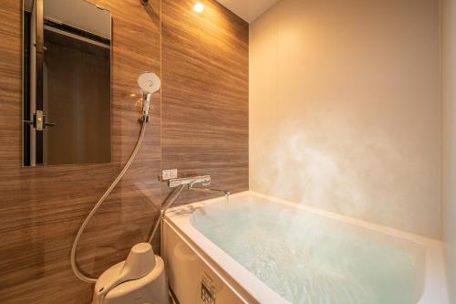 a bathroom with a bath tub with a shower at 在-Zai- in Beppu