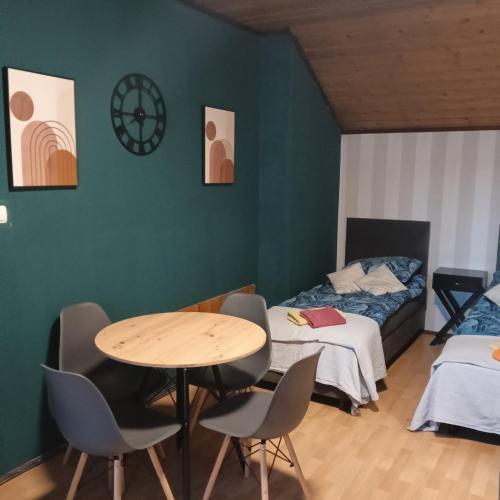 a room with a table and chairs and a bed at Hostel Róża in Żywiec