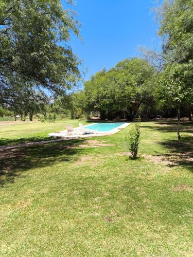 a swimming pool in a yard with two lounge chairs at Complejo Volcanes de la Puna in Tinogasta