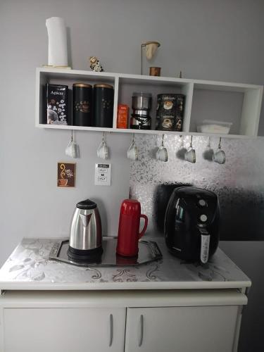a kitchen counter with a coffee pot and a tea kettle at Refúgio do Horizonte in Brazópolis