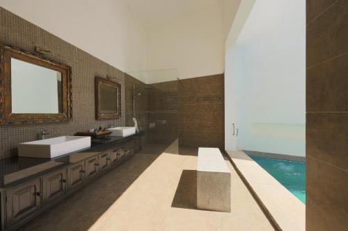 a bathroom with two sinks and a swimming pool at The Postcard Galle in Galle