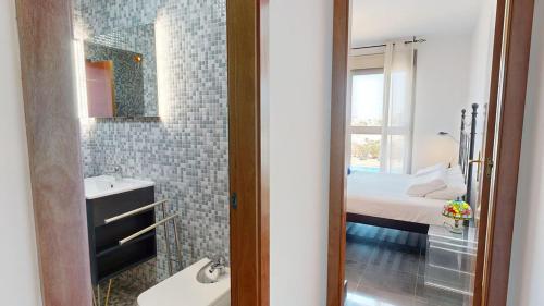 a bathroom with a sink and a bed and a mirror at Beach Apartment Marfolin 06 El Cotillo in El Cotillo