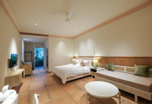 a large bedroom with a bed and a table at The Forresta Checks-In, Jaipur in Jaipur