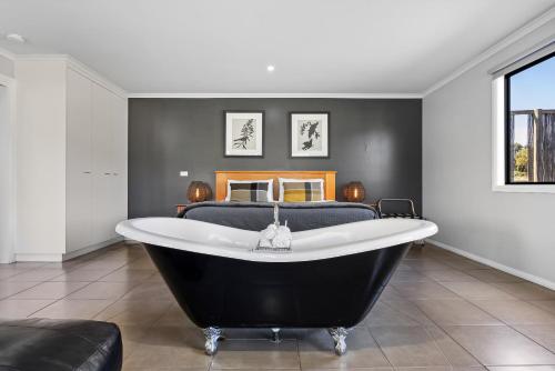 a bath tub in a bedroom with a bed at Blaze Rock Retreat in Halls Gap