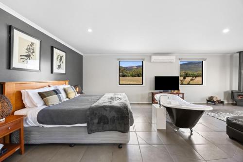 a bedroom with a bed and a tub and a television at Blaze Rock Retreat in Halls Gap
