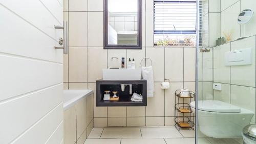 a bathroom with a sink and a toilet at Hermanus Cliff Path Lodge - No Load-shedding in Hermanus
