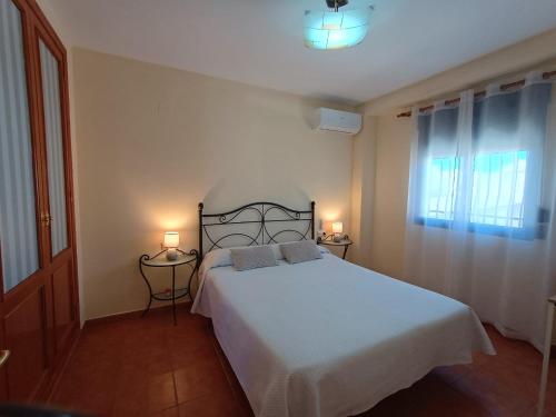 a bedroom with a white bed and two lamps at Pensión Dani in Casinos