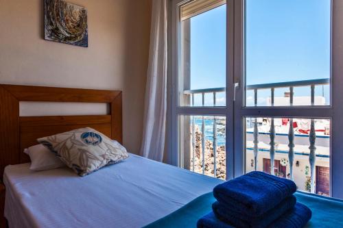 a bedroom with a bed and a large window at Casa Mika Oliastur 25 El Cotillo in El Cotillo