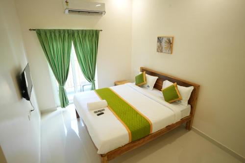a bedroom with a bed with a green curtain at Green Resort Pondicherry in Pondicherry